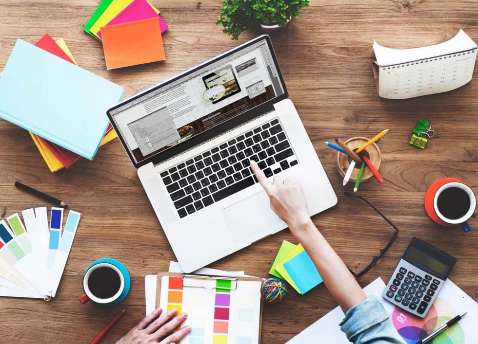 woman's hand pointing to laptop